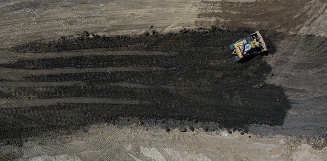 Yellow and blue plastic toy car on brown sand Petroteq Energy Inc.